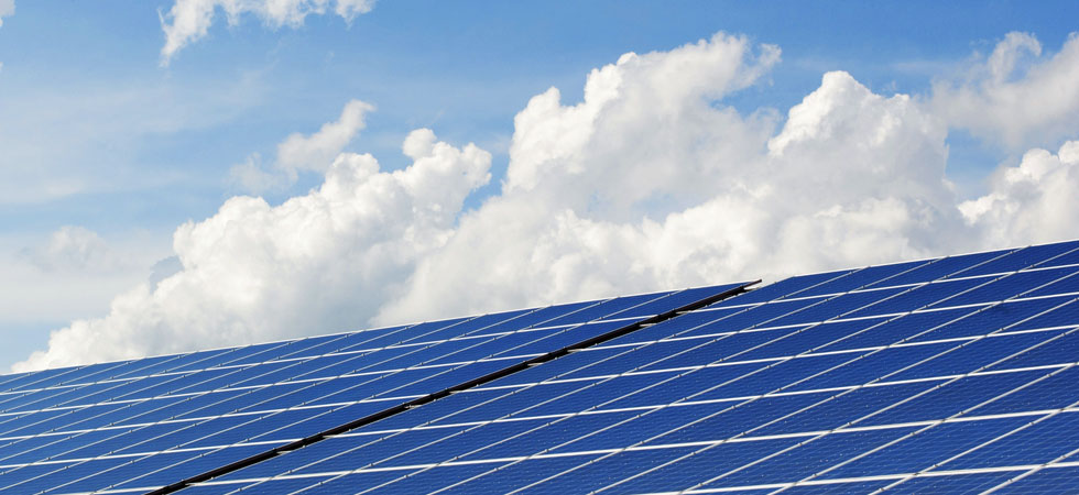 bank-of-solar-panels-with-clouds-in-the-background