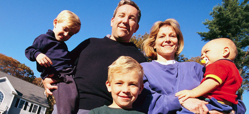 family-of-five-standing-outside-their-house