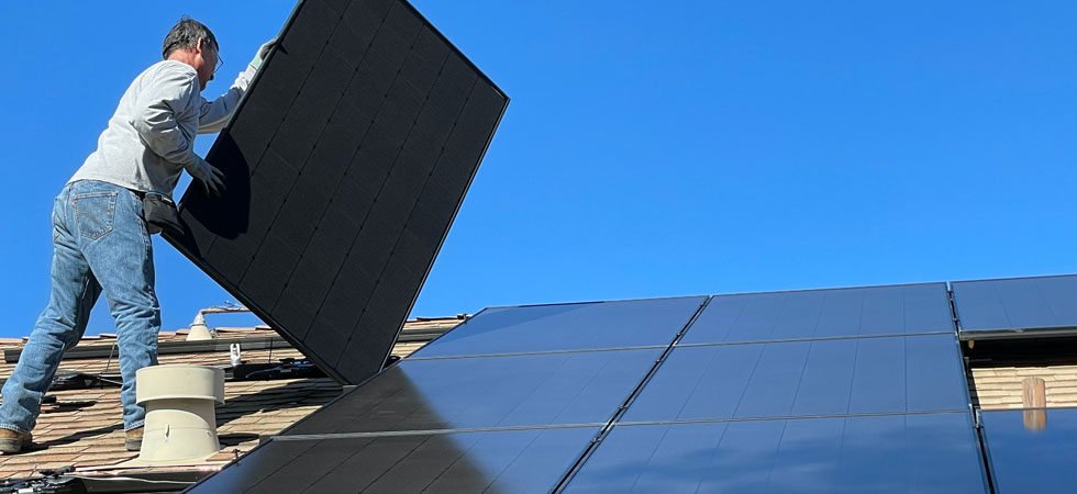 man-on-house-roof-installing-solar-panels
